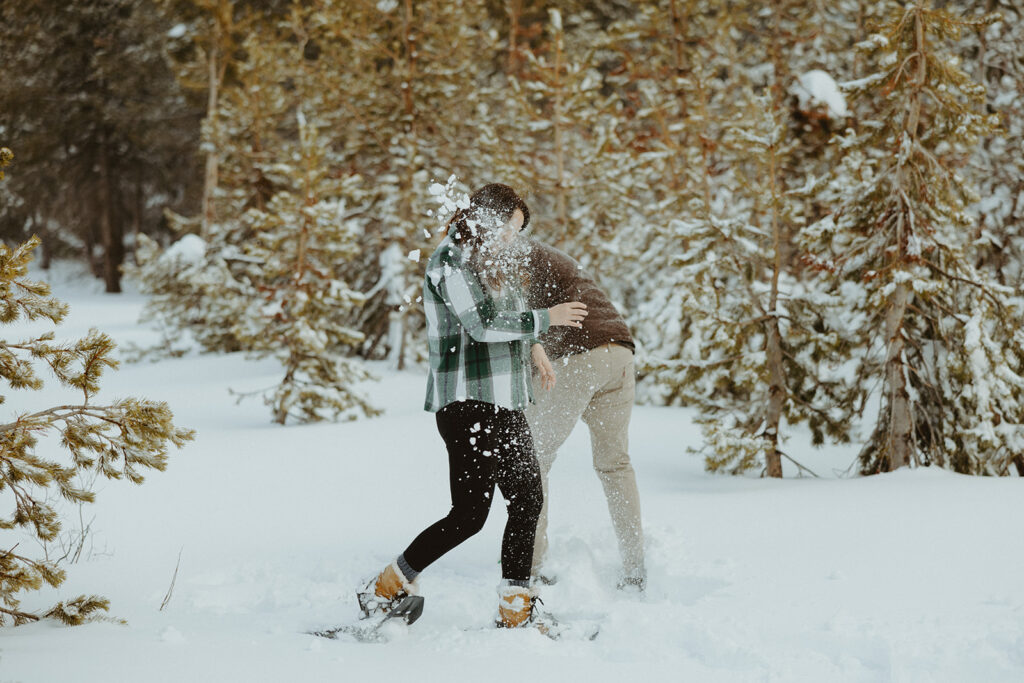 husband and wife throwing snow balls at each other 