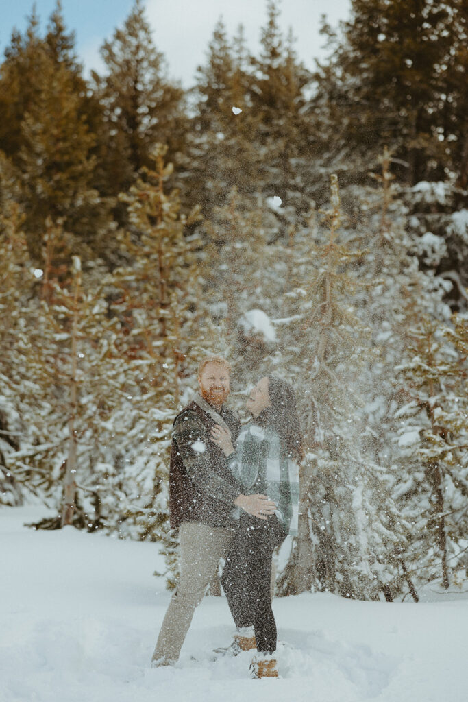 husband and wife throwing snow balls at each other 